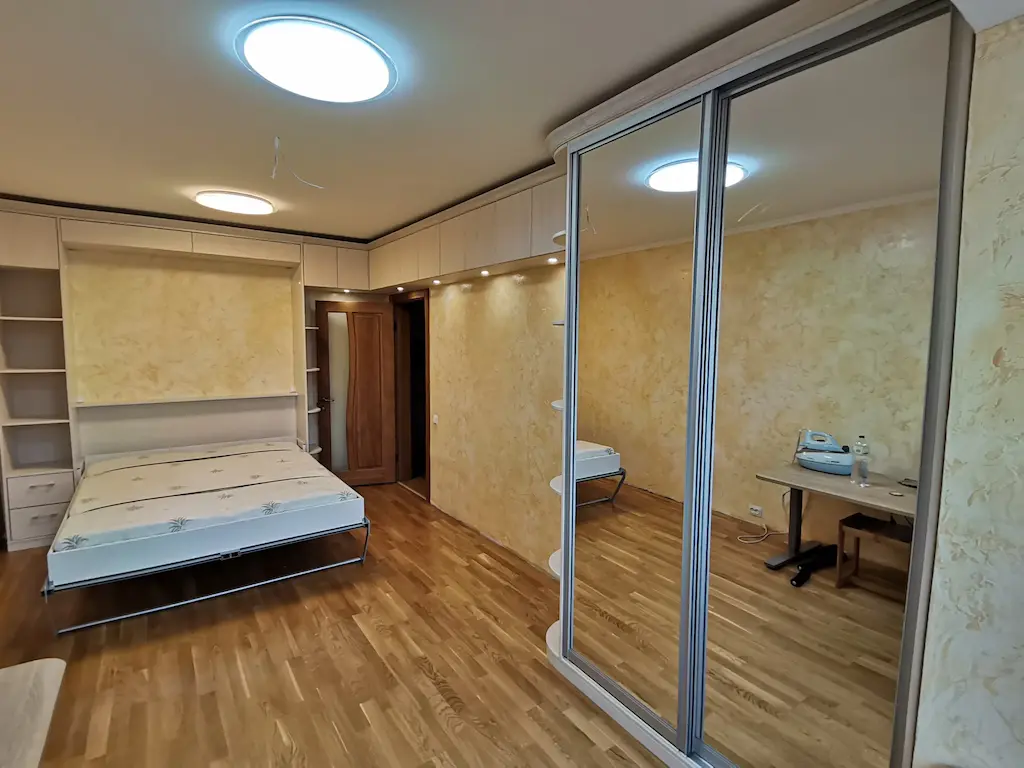 Спальня с подъемной кроватью, встроенными шкафами и точечной подсветкой